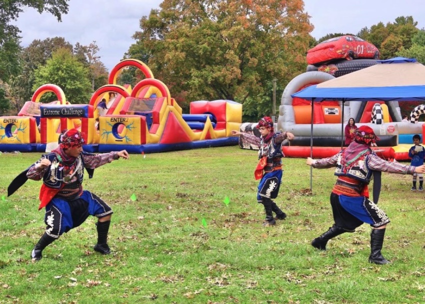 Folk dancers in traditional costume performing at a Wellspring outdoor festival